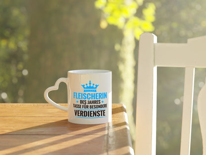 Besonderer Verdienst: Fleischerin | Schlachterei - Herzhenkel Tasse - Kaffeetasse / Geschenk / Familie