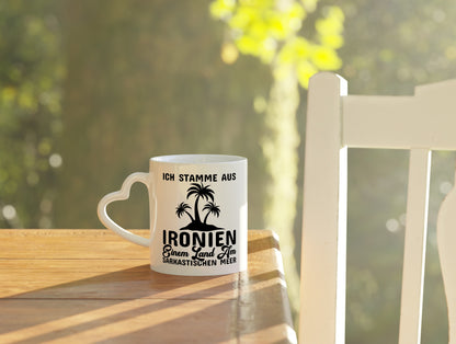 Ich stamme aus Ironien - Herzhenkel Tasse - Kaffeetasse / Geschenk / Familie